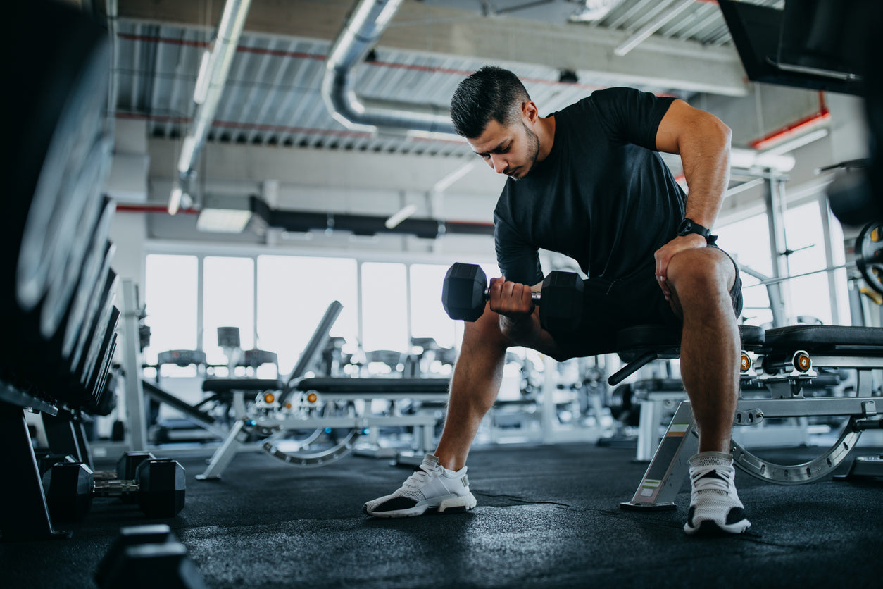 a man is doing bicep curls with dumbell in a gym