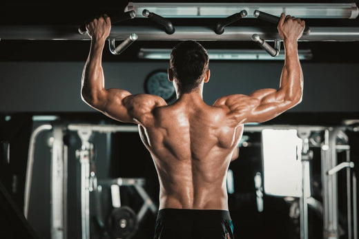 a man is doing pull ups in a gym