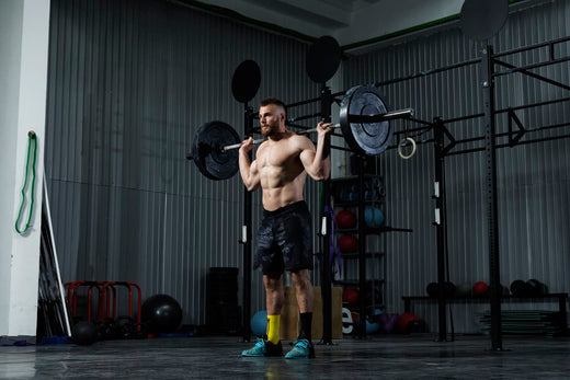 a man do barbell squats in a gym